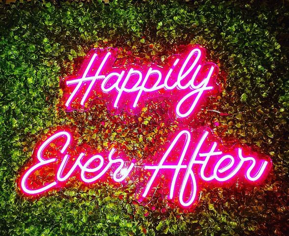 happily ever after neon sign rental and boxwood backdrop